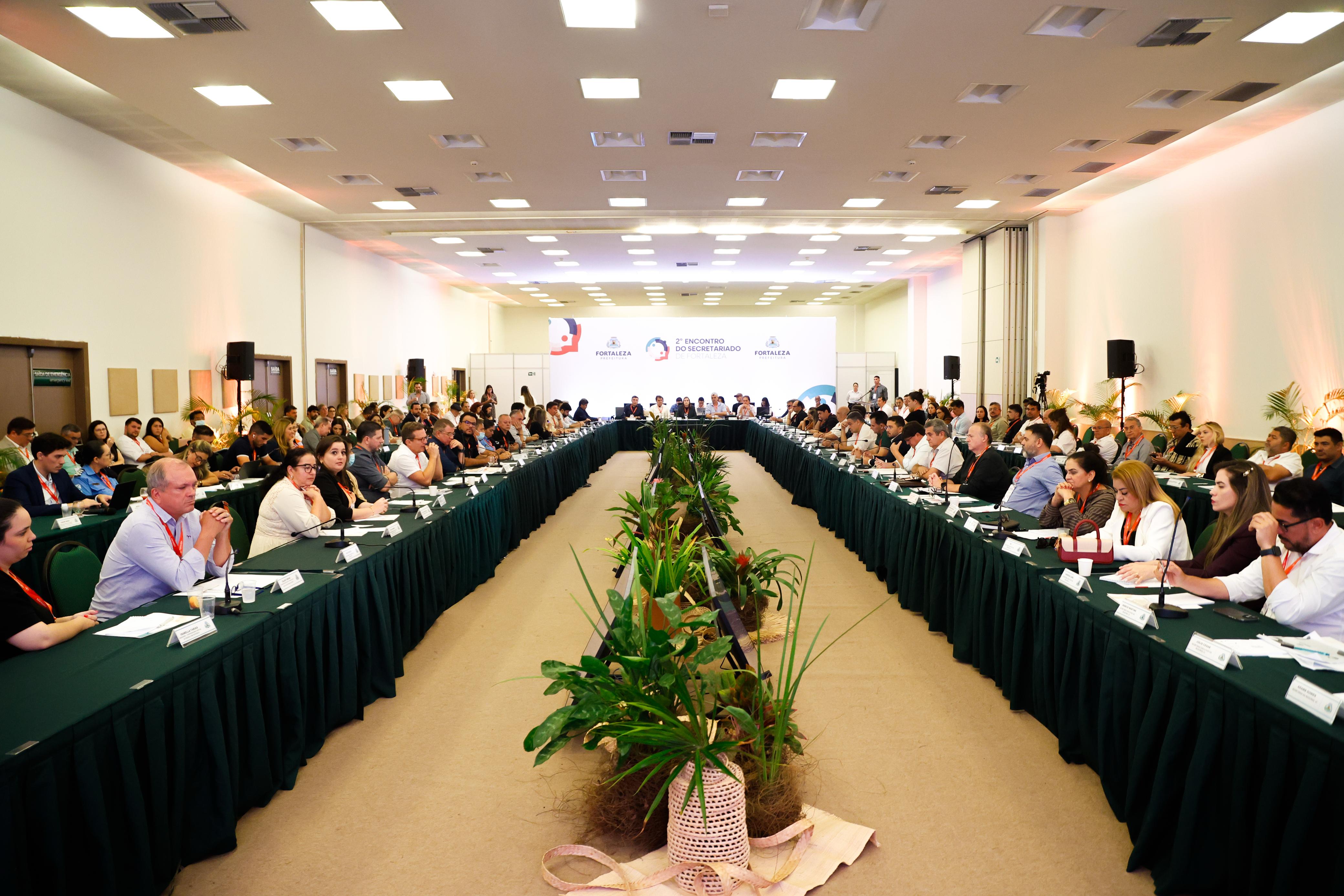 imagem aberta mostrando a mesa com as pessoas que participam da reunião